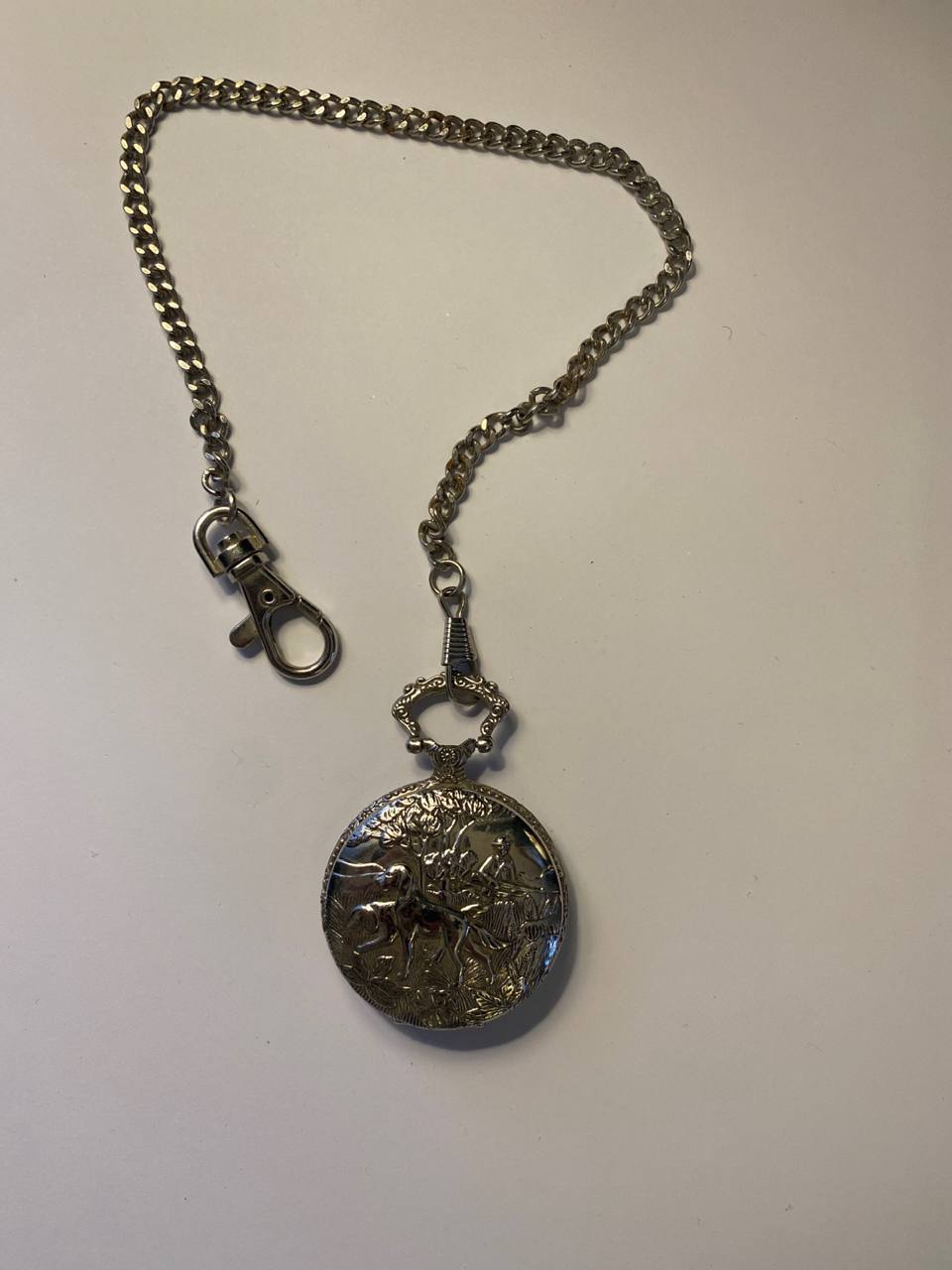 Montre à gousset publicitaire Le Chasseur Français – Scène de chasse en relief – Quartz – Chaîne et mousqueton