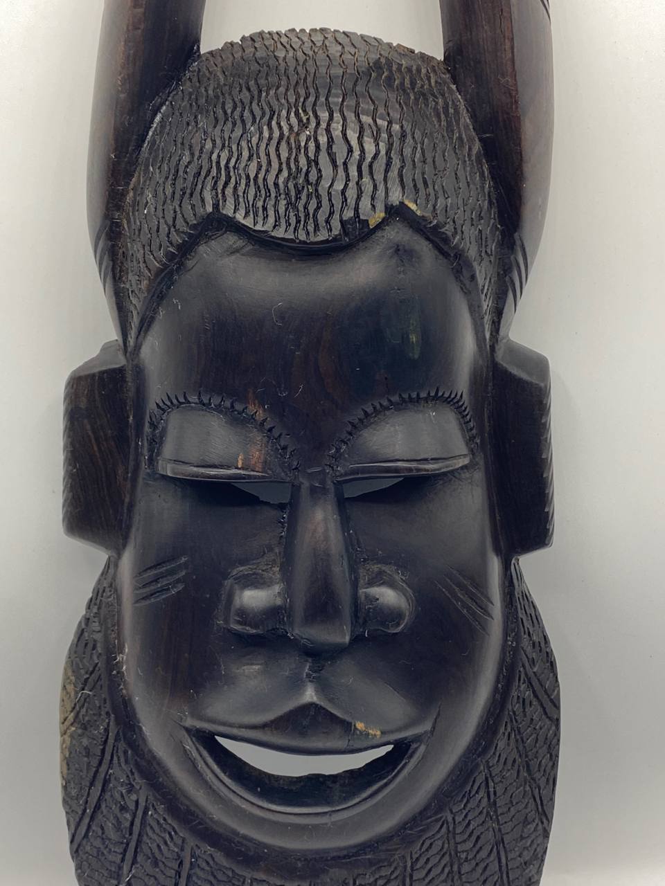 Masque africain à cornes en bois sculpté – Visage stylisé – Patine noire