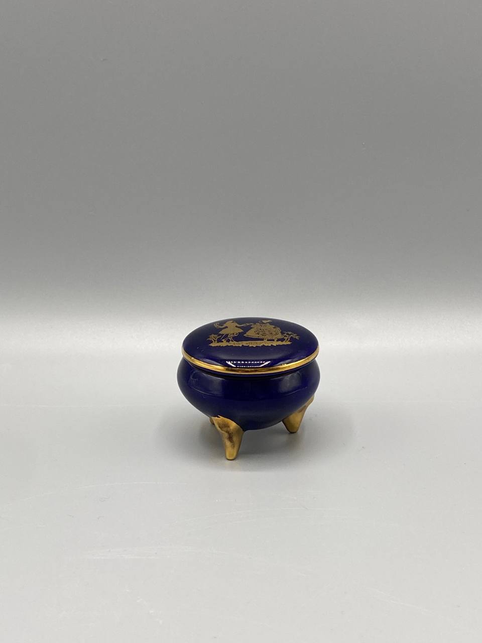 Bonbonnière miniature en porcelaine bleu de four – Scène galante dorée – Tripode pieds dorés