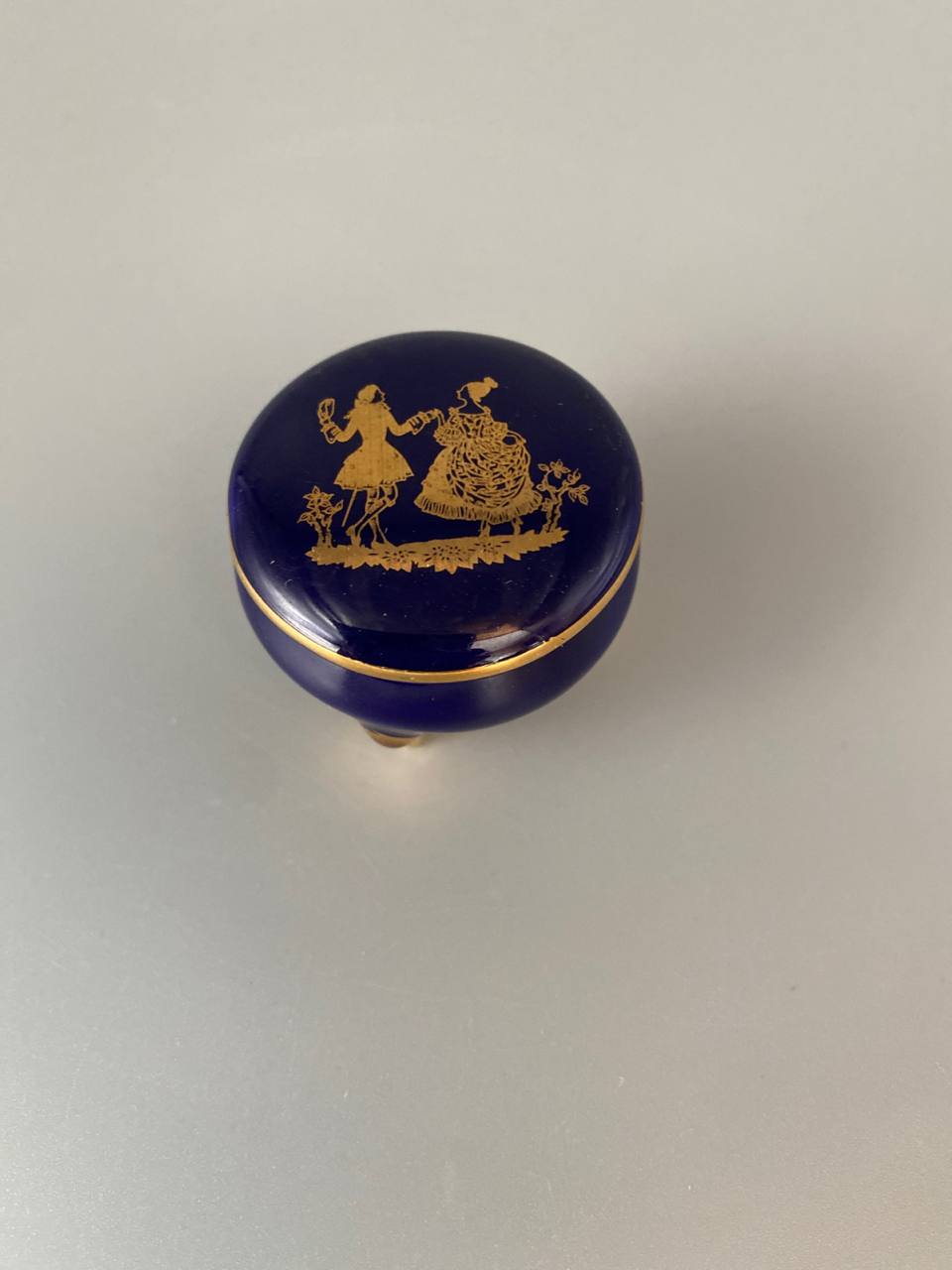 Bonbonnière miniature en porcelaine bleu de four – Scène galante dorée – Tripode pieds dorés