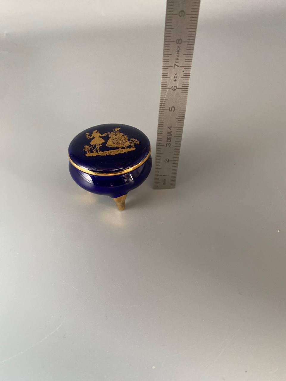 Bonbonnière miniature en porcelaine bleu de four – Scène galante dorée – Tripode pieds dorés