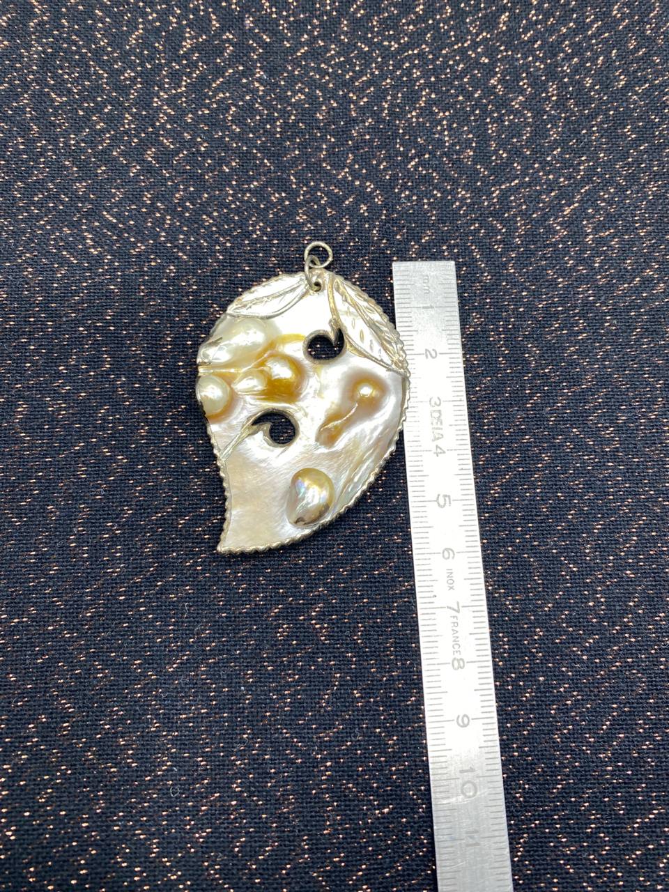 Pendentif nacre naturelle sculptée – Formations nacrées en relief – Forme feuille ajourée
