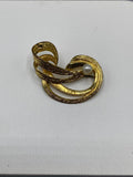 Broche tourbillon dorée – Ruban spirale texturé martelé – Perle nacrée centrale – Bijou vintage