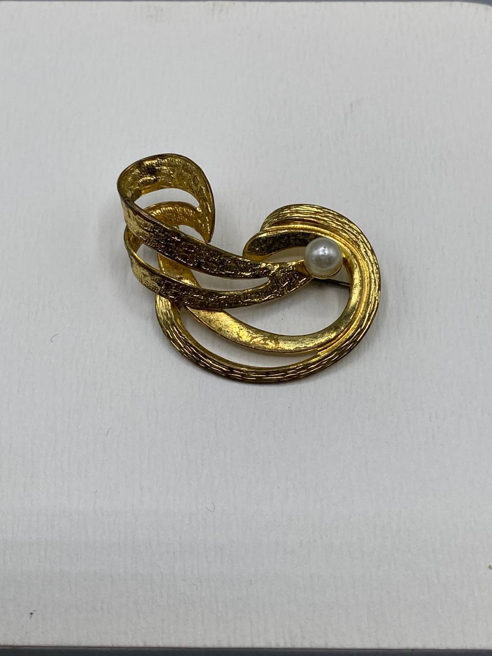 Broche tourbillon dorée – Ruban spirale texturé martelé – Perle nacrée centrale – Bijou vintage