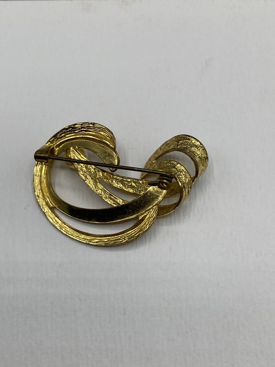 Broche tourbillon dorée – Ruban spirale texturé martelé – Perle nacrée centrale – Bijou vintage