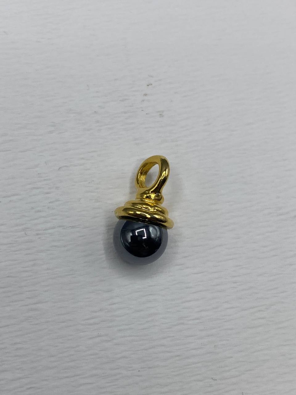 Pendentif breloque perle hématite en monture dorée enroulée
