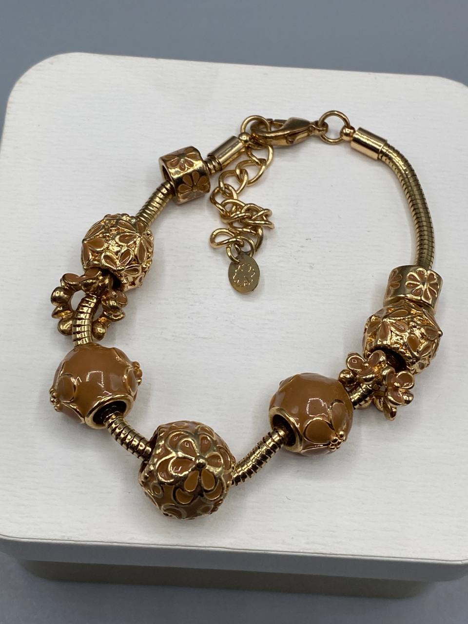 Bracelet charms doré serpentine, perles émaillées caramel et charms ajourés floraux