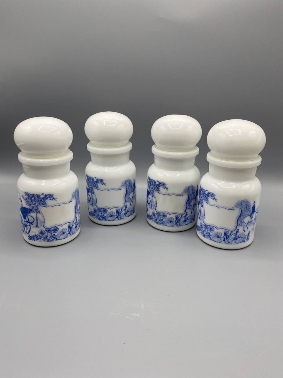 Série de 4 flacons apothicaire en opalin blanc – Décor bleu scènes de calèches – Bouchons boule – circa 1960-1970