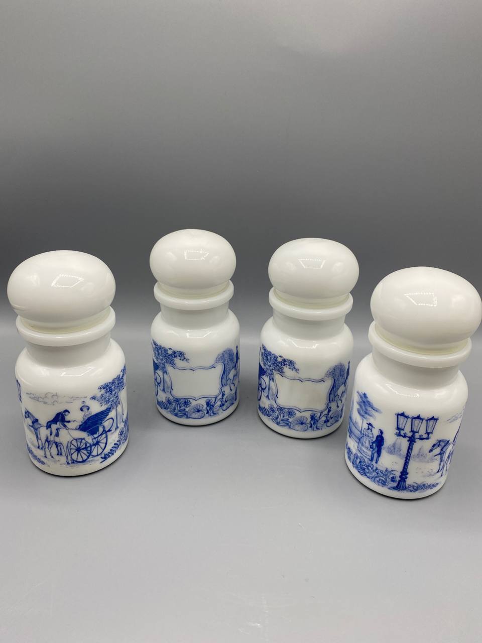 Série de 4 flacons apothicaire en opalin blanc – Décor bleu scènes de calèches – Bouchons boule – circa 1960-1970