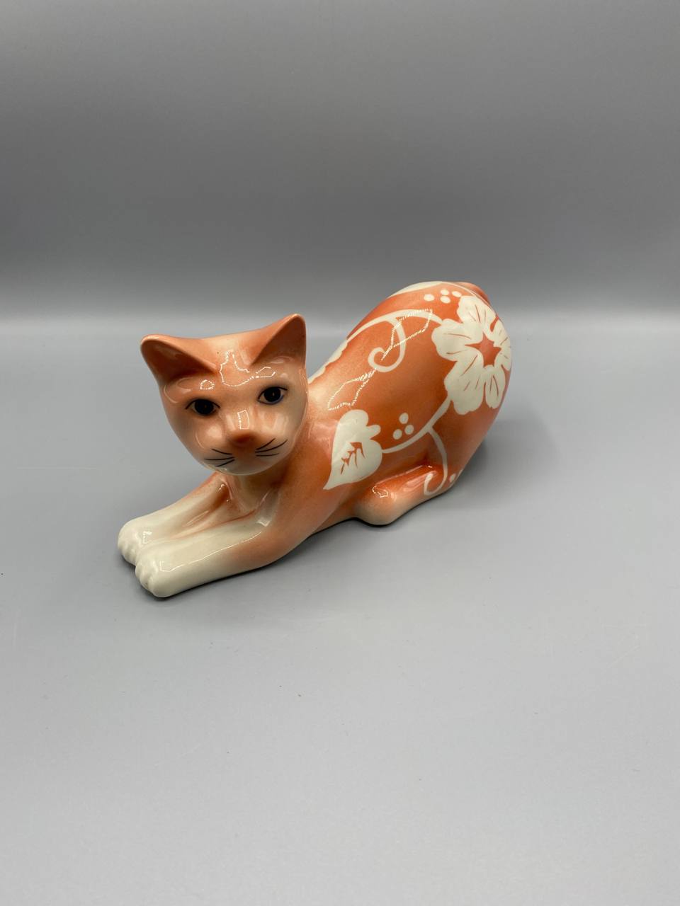 Chat en céramique émaillée – Décor floral blanc sur fond orange – Figurine vintage