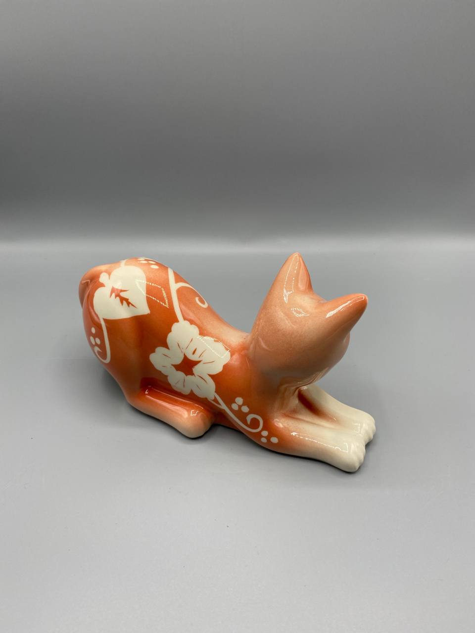 Chat en céramique émaillée – Décor floral blanc sur fond orange – Figurine vintage