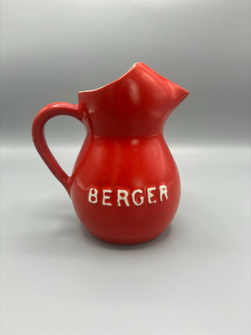 Pichet publicitaire Berger, céramique émaillée rouge, lettrage relief, années 50-70