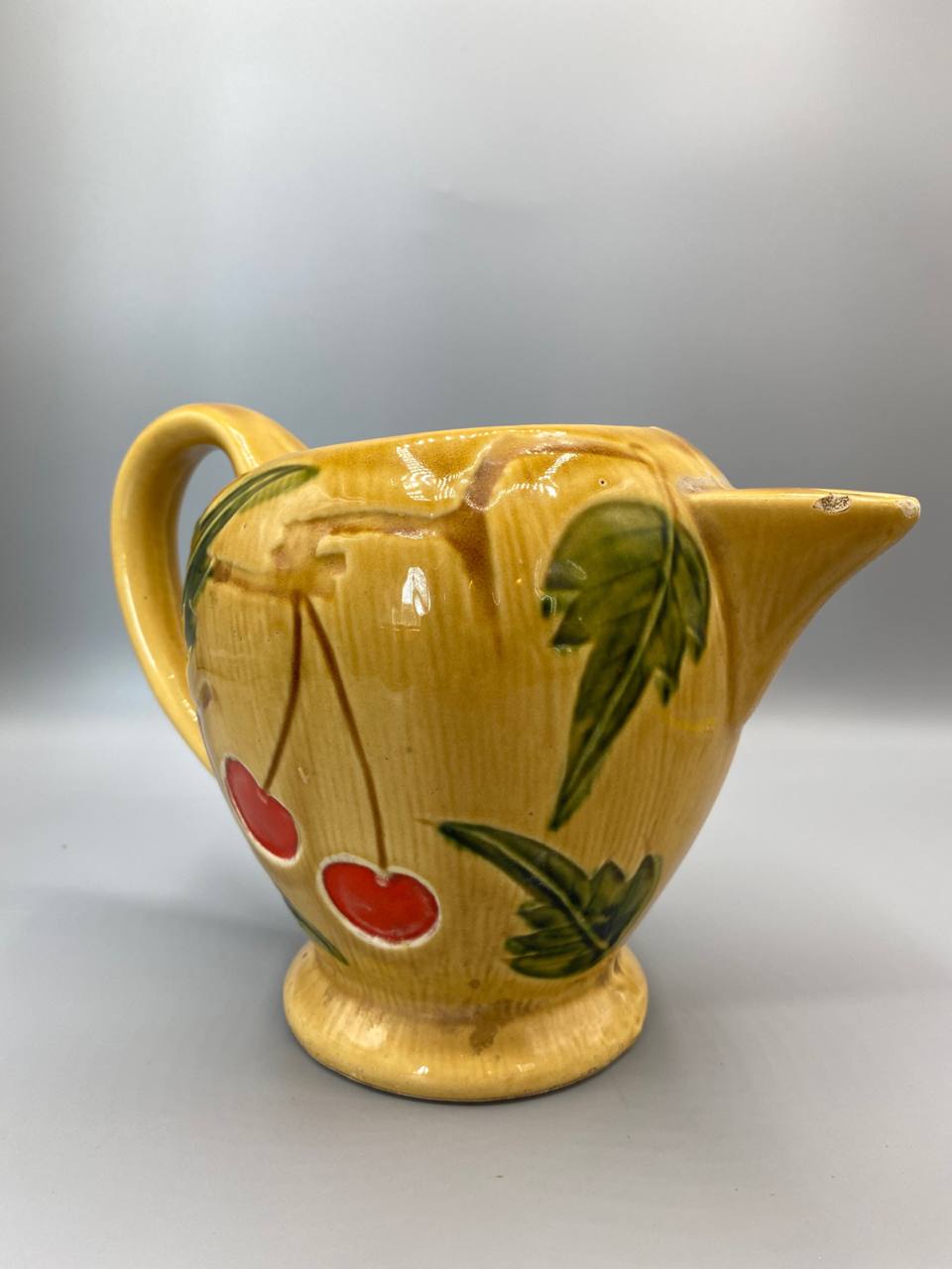 Vue de dos pichet faïence jaune décor cerises rouges