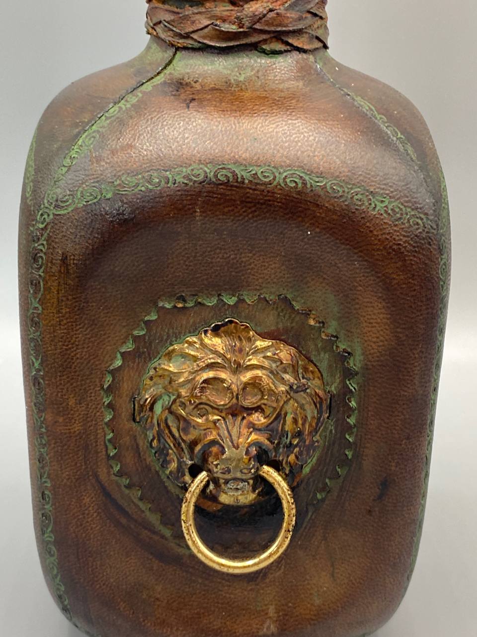 Détail médaillon tête de lion laiton doré sur cuir estampé