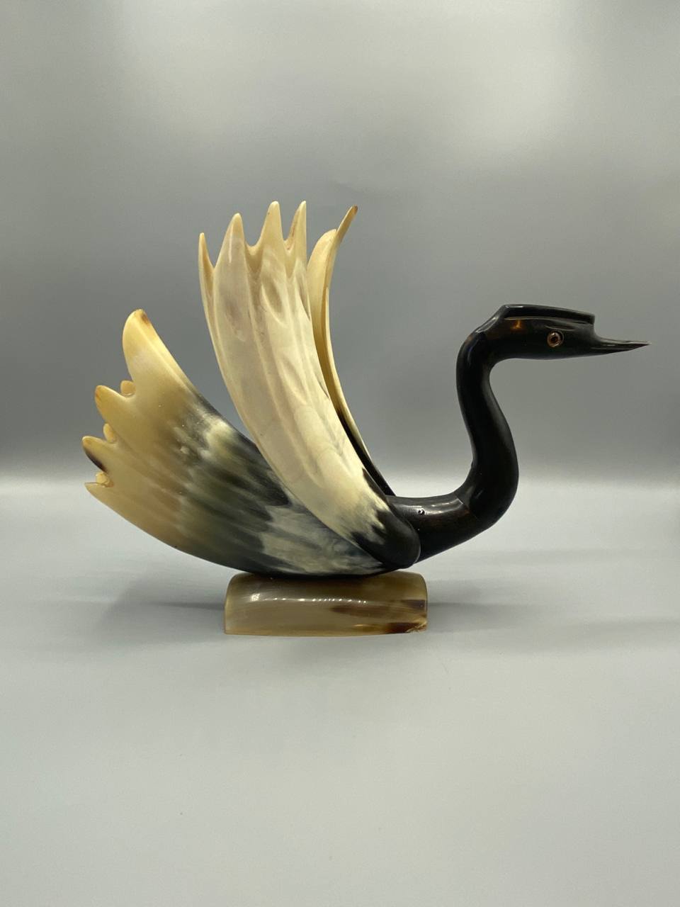 Vue de trois quarts cygne corne naturelle sculptee polie socle corne blonde