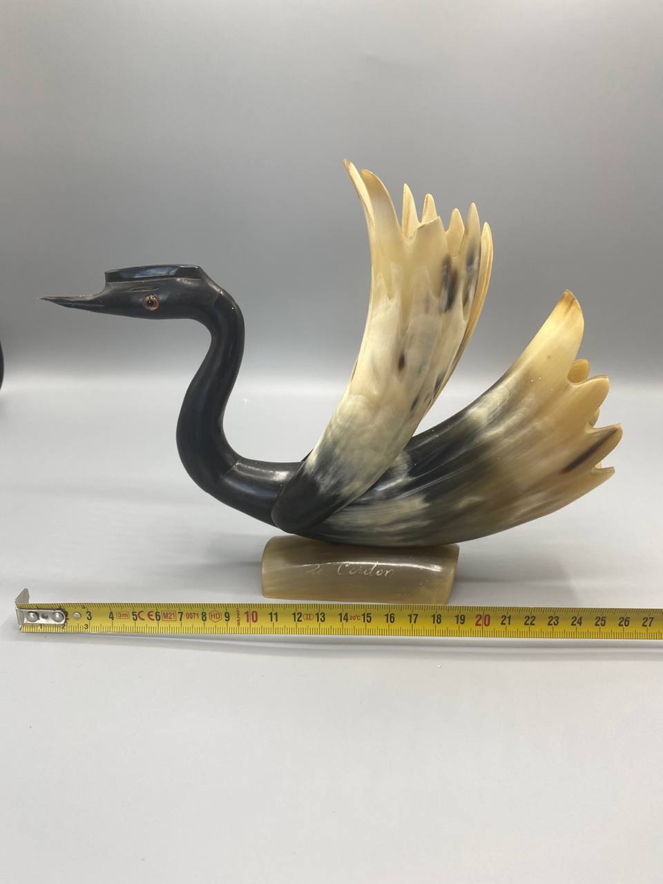 Vue de profil cygne corne naturelle sculptee polie ailes deployees socle