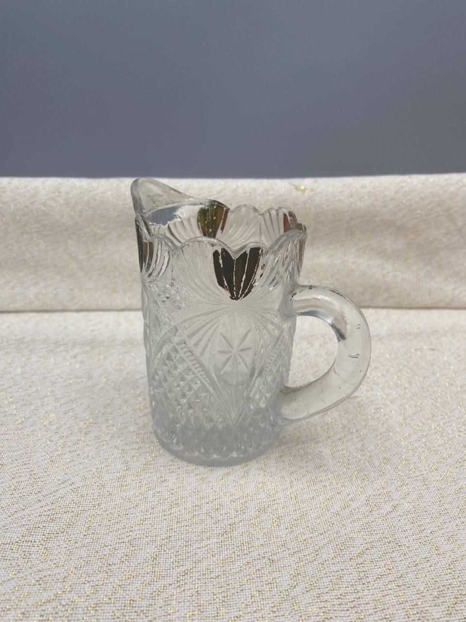 Petit crémier verre pressé moulé col festonné doré bec verseur anse anneau vue de face