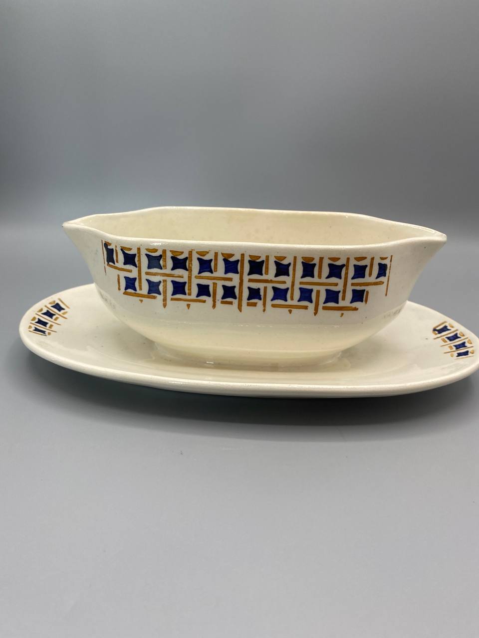 Saucère faïence ivoire décor losanges bleu cobalt or Maryse Givors vue de face avec présentoir