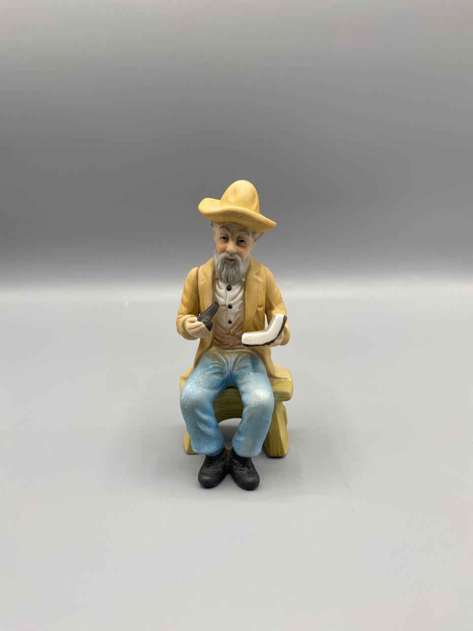 Figurine biscuit vieil homme assis chapeau paille pipe livre vue de face
