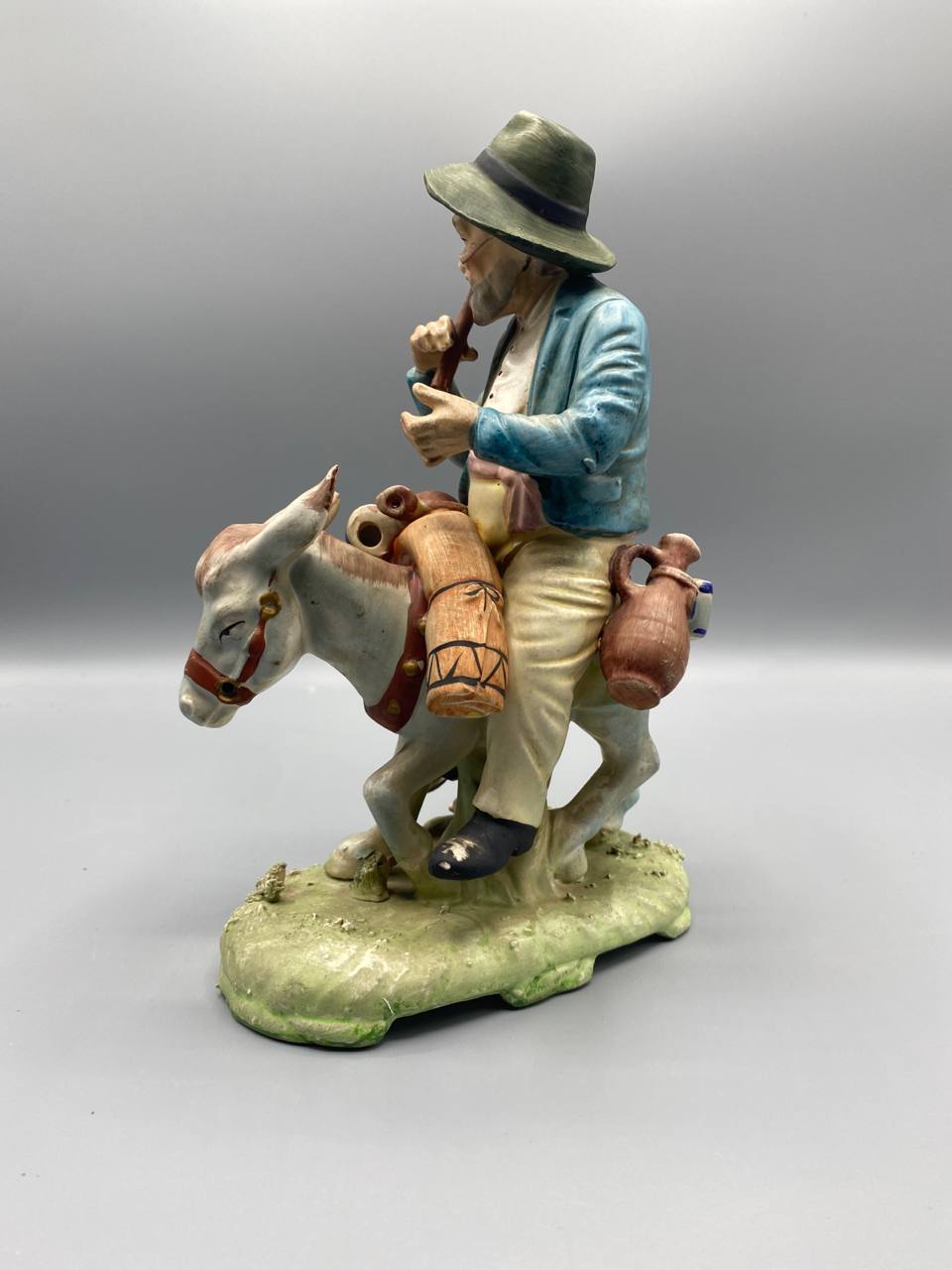 Vue de profil groupe biscuit paysan âne cruches gourde raisins polychrome