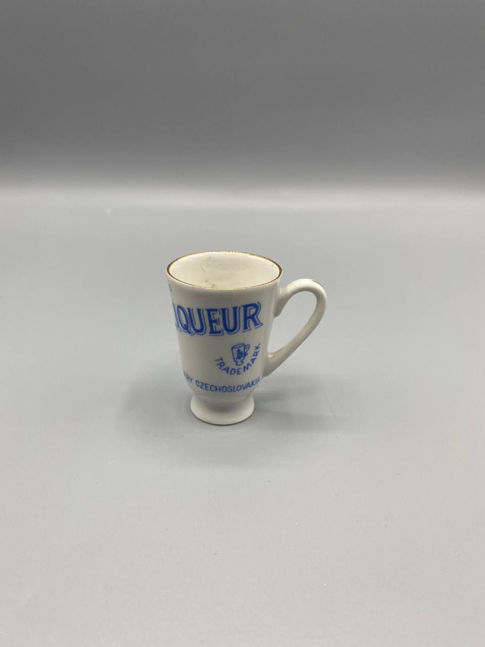 Tasse à liqueur publicitaire Becherovka porcelaine blanche décor bleu cobalt vue de face
