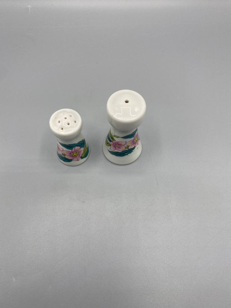 Vue de dessus salière 5 trous poivrière 1 trou bouchons porcelaine blanche