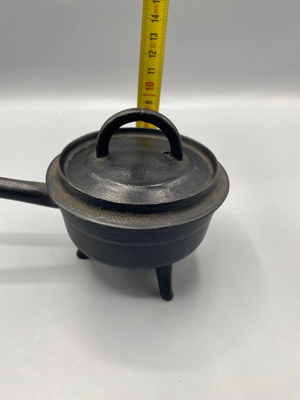 Mesure hauteur cocotte tripode fonte noire avec couvercle environ 9 cm mètre visible