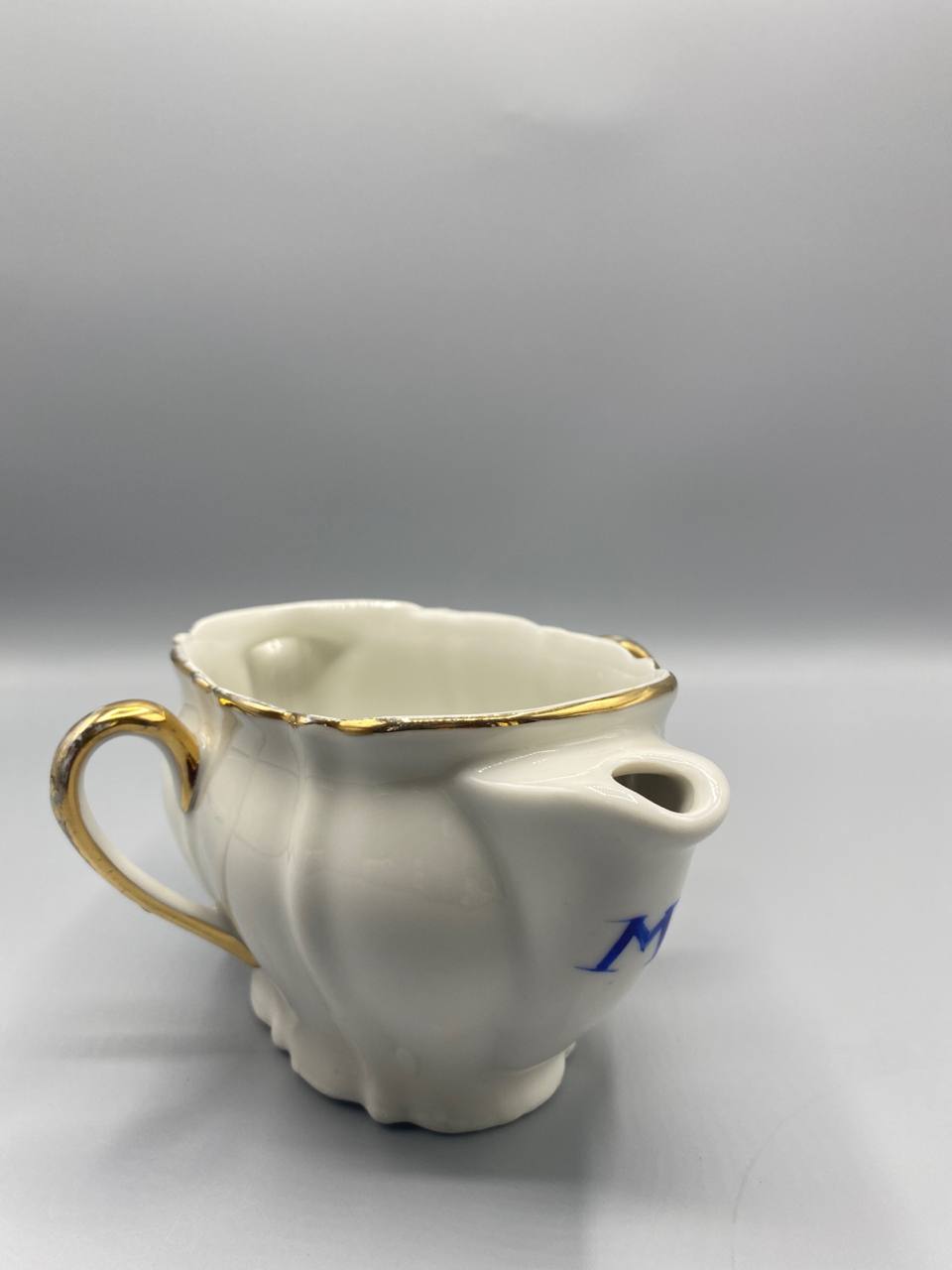 Vue de trois quarts saucière porcelaine blanche côtelée monogramme bleu cobalt bec verseur