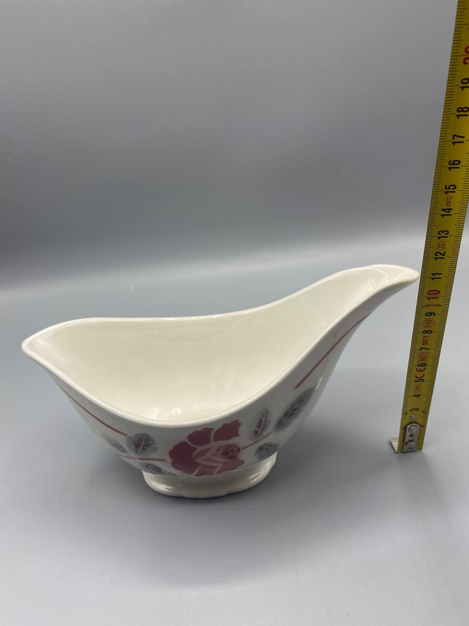 Vue de côté saucière faïence fine mesure hauteur environ 9 cm mètre visible