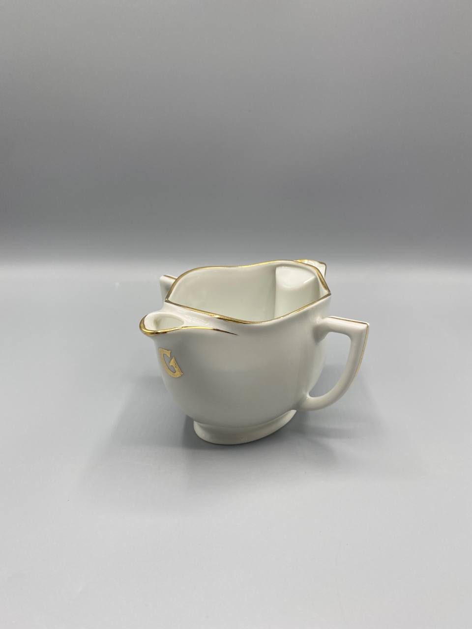Vue de trois quarts saucière porcelaine blanche Compagnie Nationale bec verseur anse rectangulaire