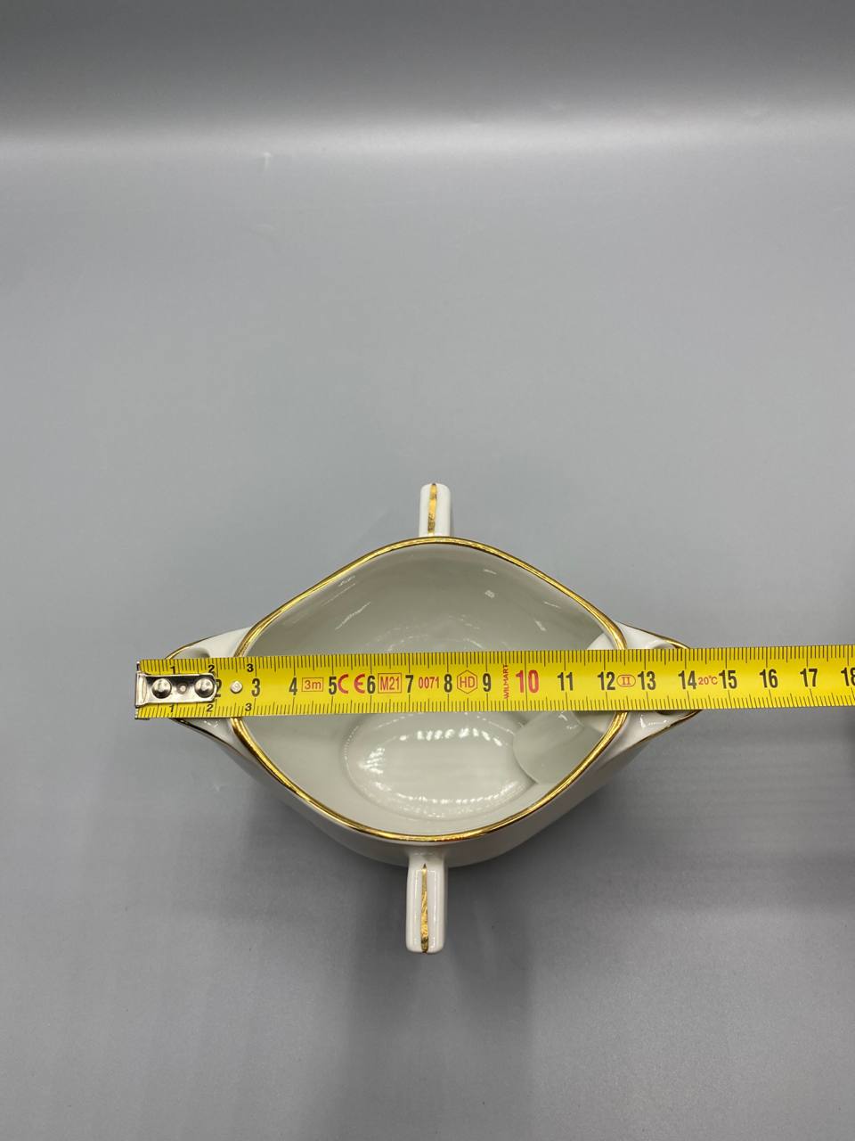 Vue de dessus saucière porcelaine blanche mesure largeur hors tout environ 15 cm mètre visible
