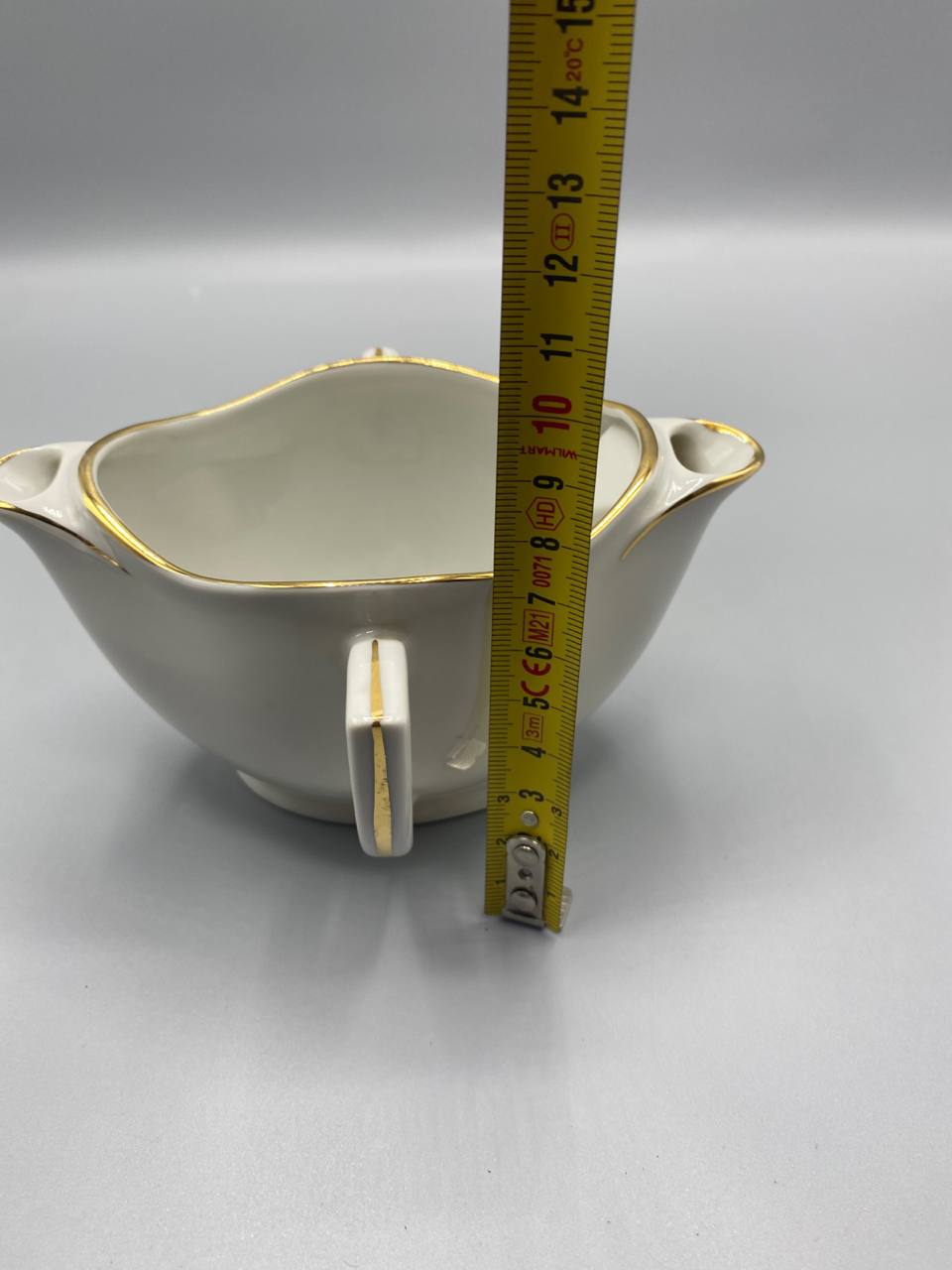 Vue de côté saucière porcelaine blanche mesure hauteur environ 8 cm mètre visible