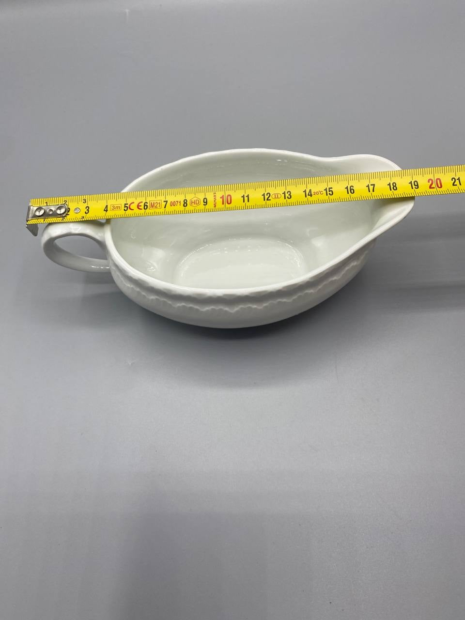 Vue de dessus saucière porcelaine blanche mesure longueur environ 20 cm mètre visible