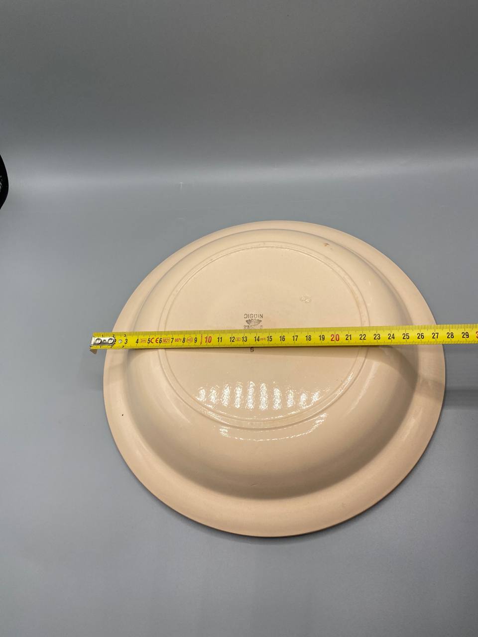 Vue de dessus revers plat creux faïence crème saumonée mesure diamètre 26 cm mètre visible