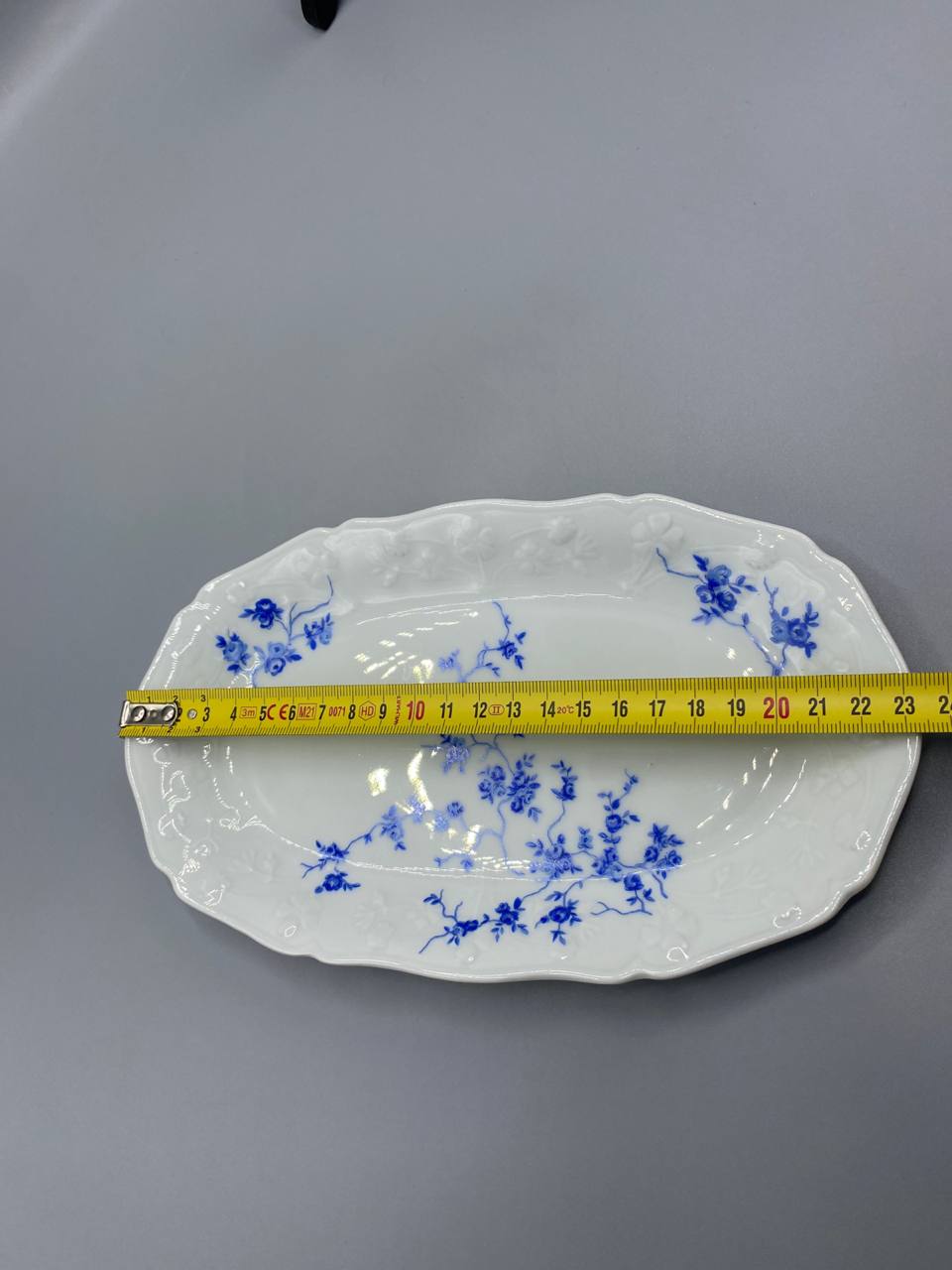 Vue de dessus plat ovale porcelaine décor rosiers bleu cobalt mesure longueur 24 cm mètre visible