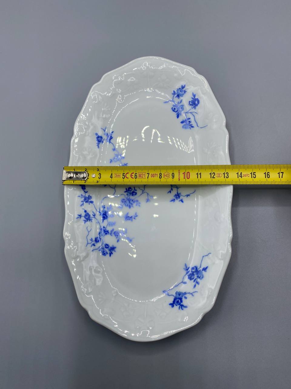 Vue de dessus plat ovale porcelaine décor rosiers bleu cobalt mesure largeur 17 cm mètre visible