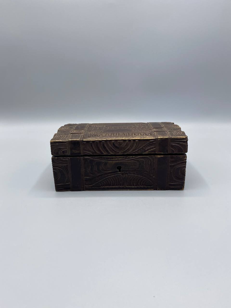 Coffret bois sculpté brun décor volutes rinceaux relief ferrures laiton doré couvercle fermé vue de face