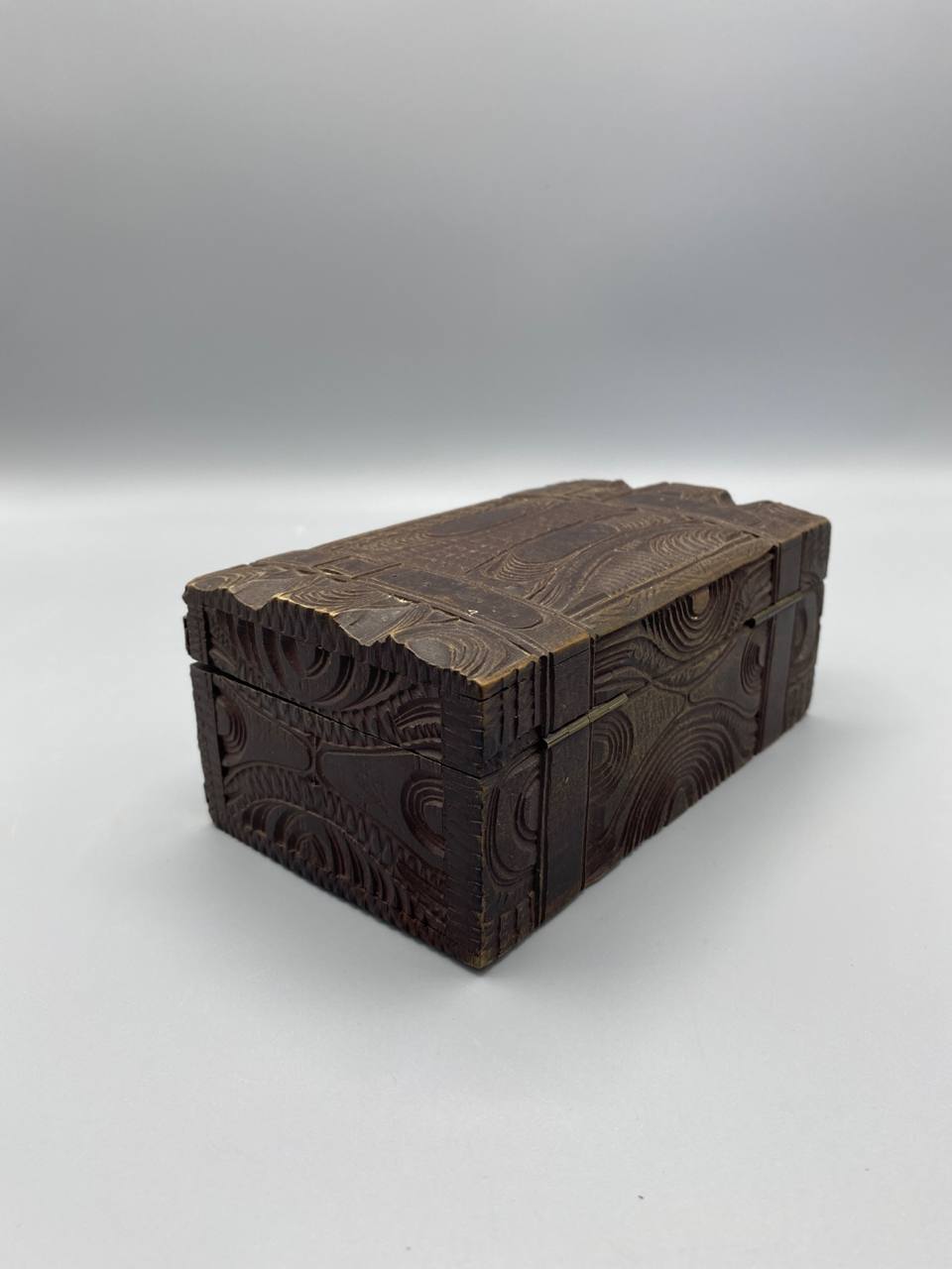 Coffret bois sculpté brun vue de trois quarts décor relief angles ferrures laiton doré