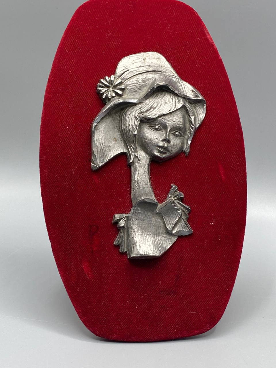 Plaque décorative murale fillette chapeau large bord marguerite étain moulé velours rouge gros plan