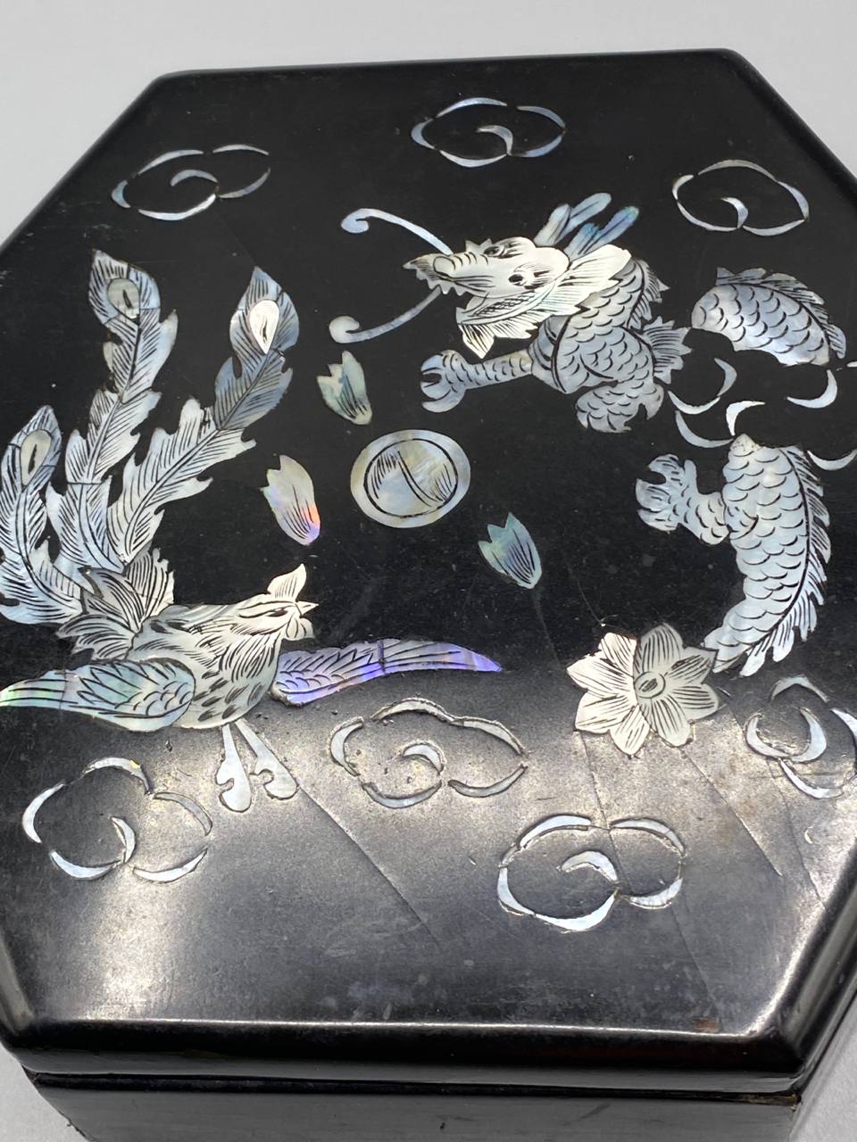 Gros plan marqueterie nacre dragon impérial phénix reflets bleutés violacés laque noire détail
