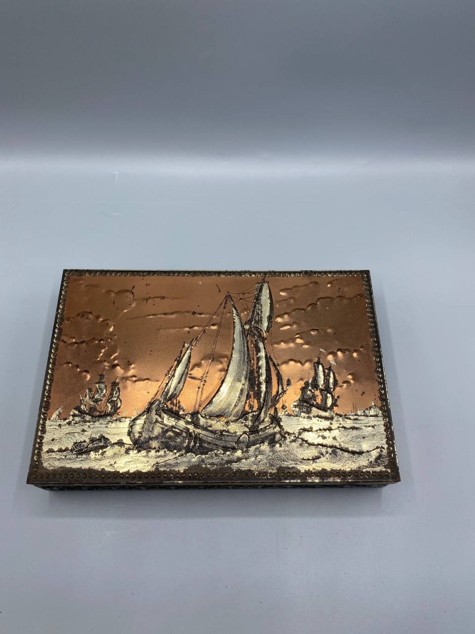 Boîte métal embossé cuivré vue de dessus couvercle décor voiliers hollandais relief