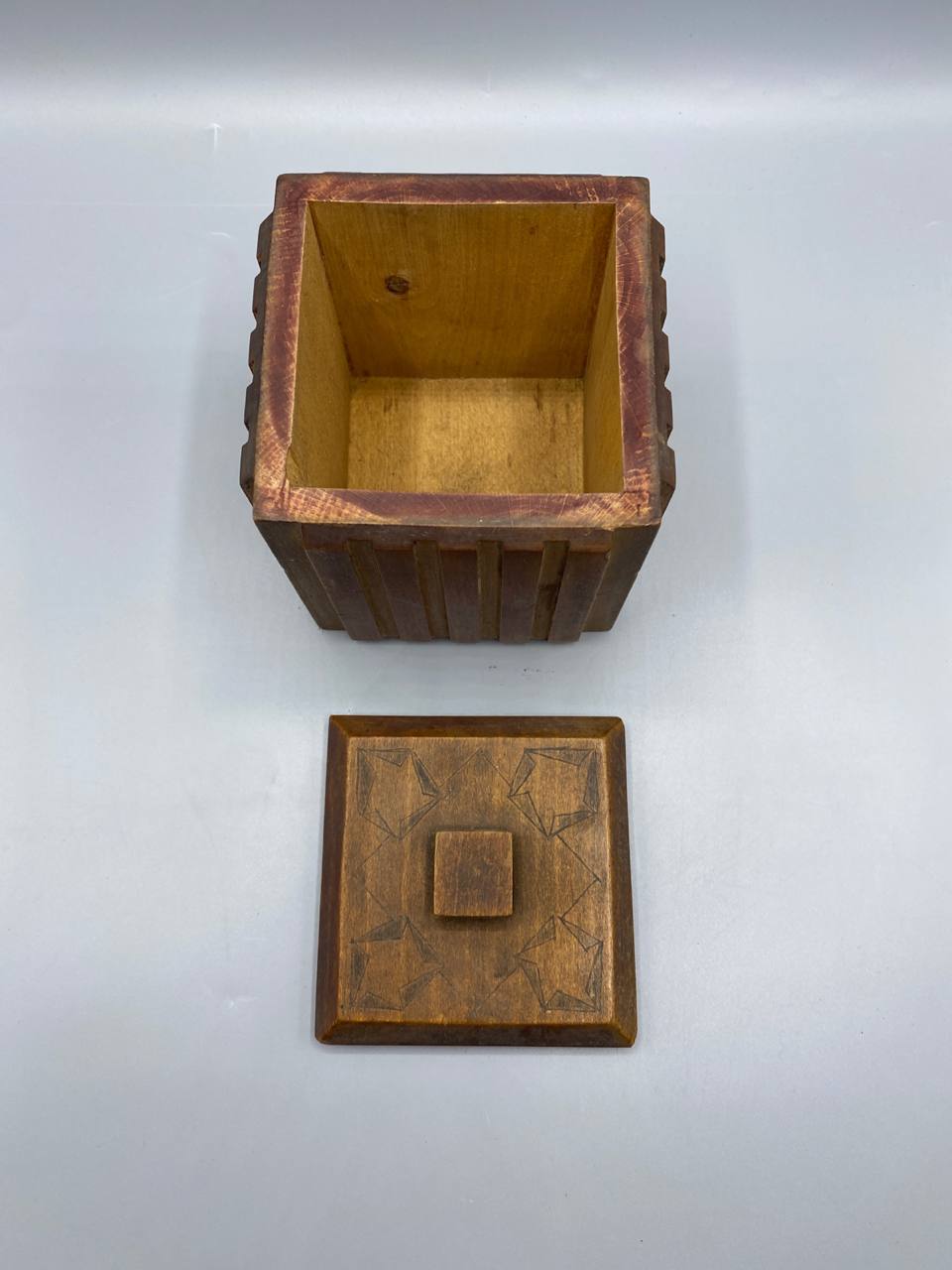 Boîte cubique bois sculpté ouverte intérieur bois clair couvercle motifs géométriques gravés vue de dessus