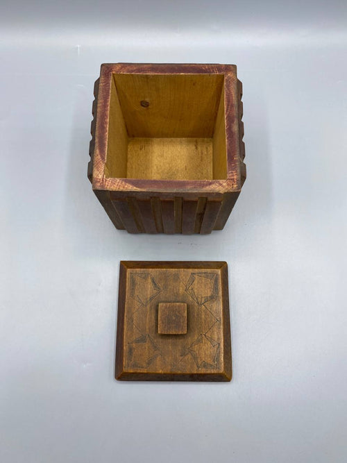 Boîte cubique bois sculpté ouverte intérieur bois clair couvercle motifs géométriques gravés vue de dessus