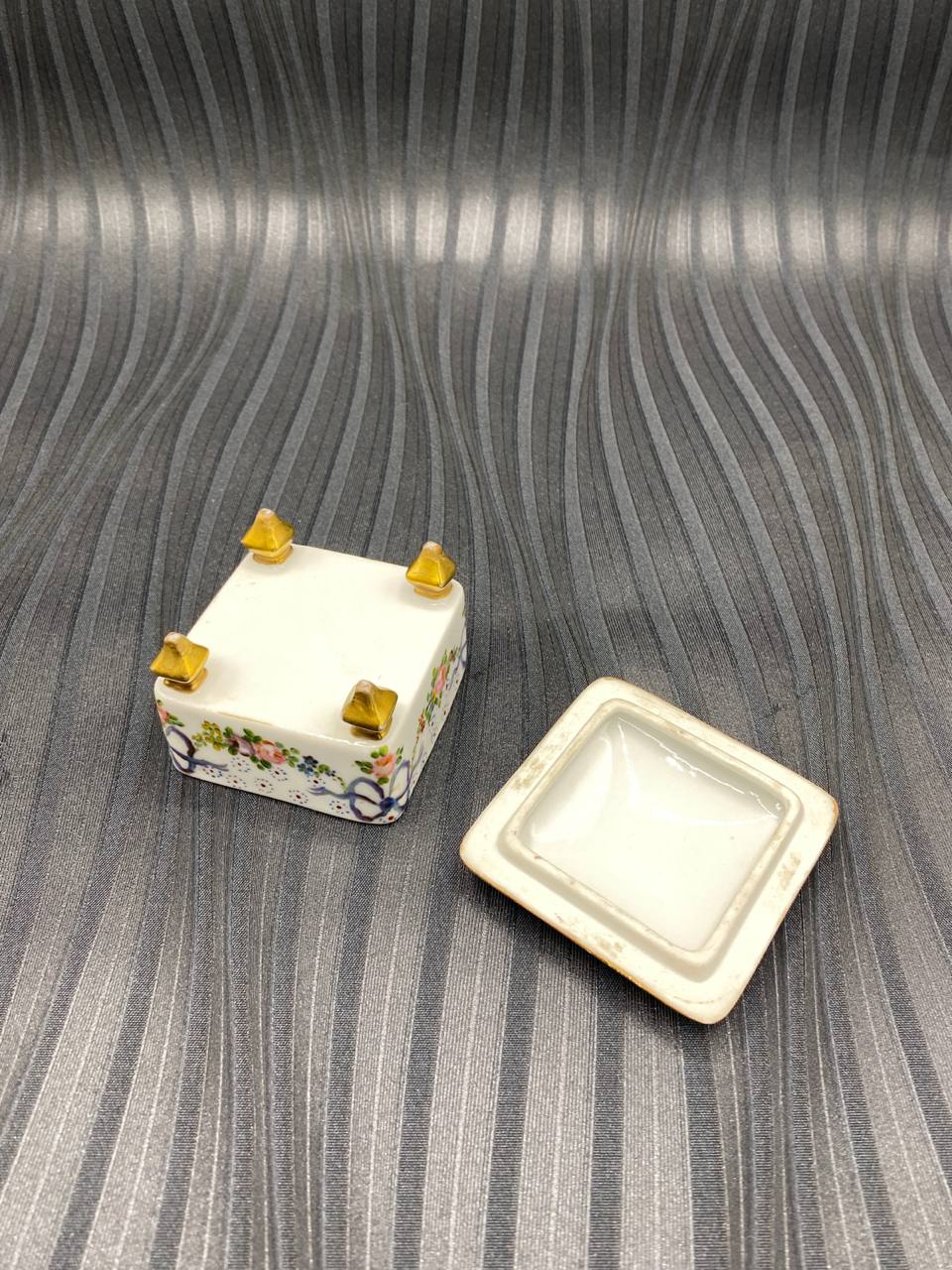 Boîte à bijoux porcelaine ouverte, intérieur blanc, fond du couvercle non signé, pieds dorés pyramidaux