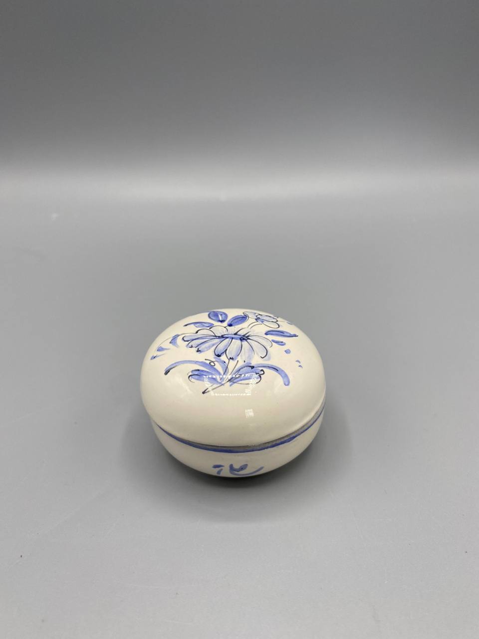 Boîte ronde faïence signée, couvercle fermé, décor floral bleu peint à la main sur fond blanc crème