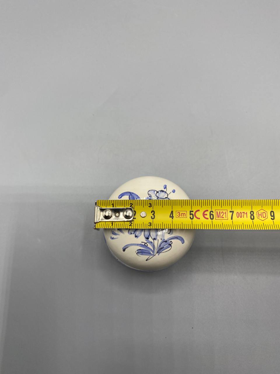 Boîte ronde faïence avec mètre ruban, diamètre environ 8 cm, vue de dessus