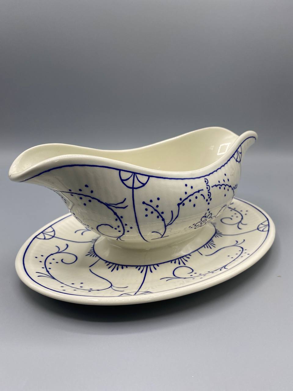 Saucière faïence Copenhague, vue de trois quarts, bord ondulé à deux becs verseurs