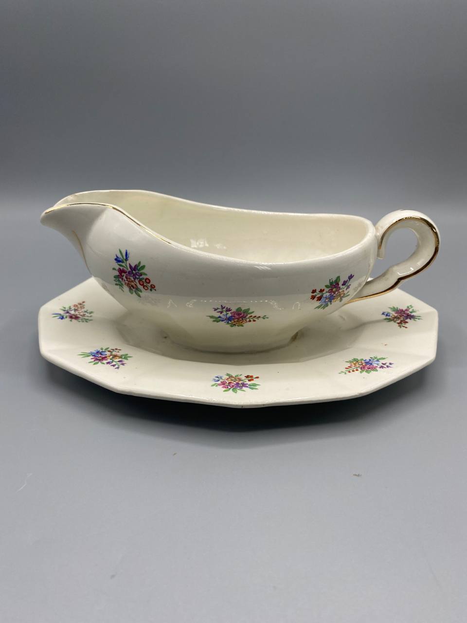 Saucière porcelaine opaque Porcelor Ceranord, vue de face avec dormant octogonal, semis floral polychrome et filet doré