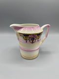 Pot à lait porcelaine fine, vue de face, décor néo-Louis XVI guirlandes roses sur fond bleu cobalt, bandes roses
