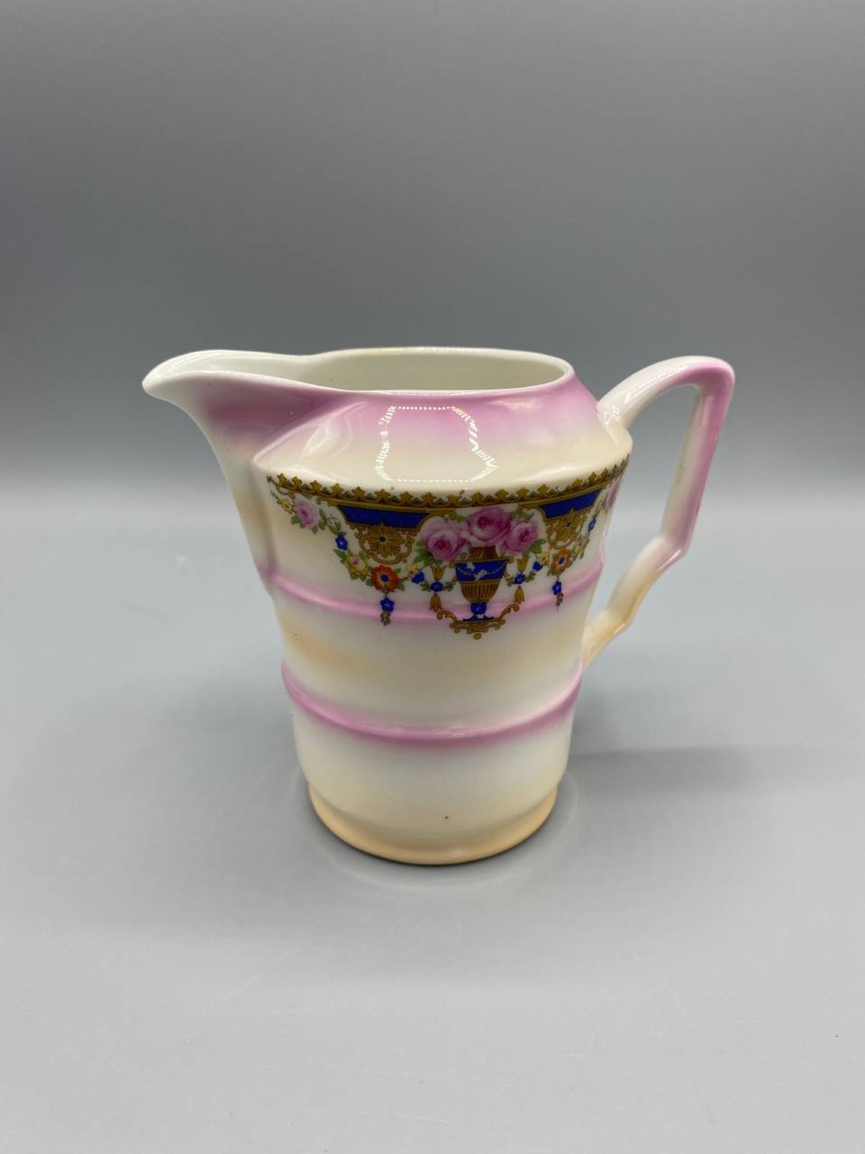 Pot à lait porcelaine fine, vue de face, décor néo-Louis XVI guirlandes roses sur fond bleu cobalt, bandes roses